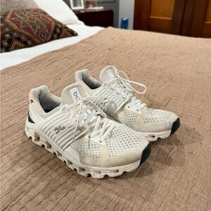 On Running Cream and Black Sneakers